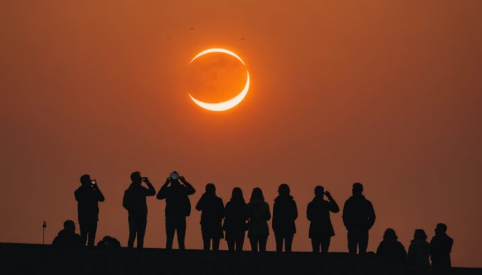 Éclipse solaire partielle en forme de croissant dans un ciel orange au-dessus d'une skyline européenne